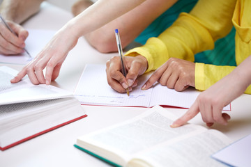 close up of students hands writing to notebooks