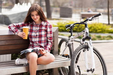 Young woman drinking coffee on a bicycle trip