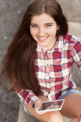 Obraz premium Face portrait of young woman using a tablet pc