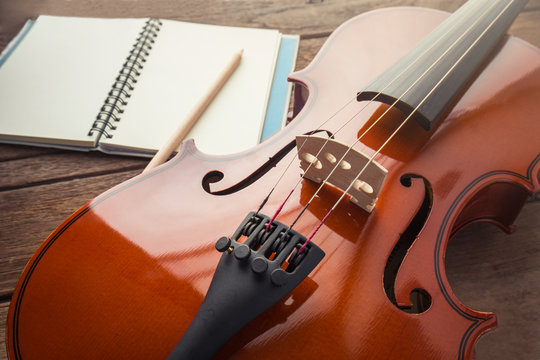 Close up of violin and book on wooden table