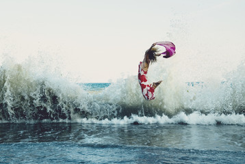 Naklejka premium Woman jumping on the beach 