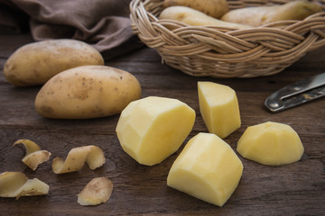 Potato and slices on wooden table