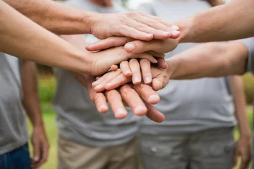 Happy volunteer family putting their hands together  © WavebreakmediaMicro