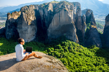 Man with laptop on the mountains