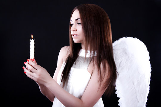 Beautiful young angel with a candle