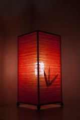 Moody lamp with red reflections on a night stand