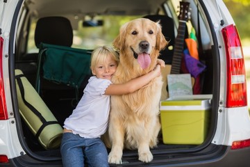 Smiling little girl with her dog in car trunk © WavebreakMediaMicro