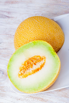 Ripe Galia melon and its slice on plate