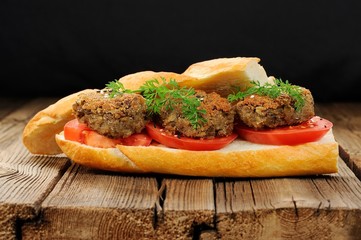 Lentil patty sandwich with tomato and carrot greens in old woode