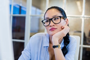 Thoughtful businesswoman sitting at her desk