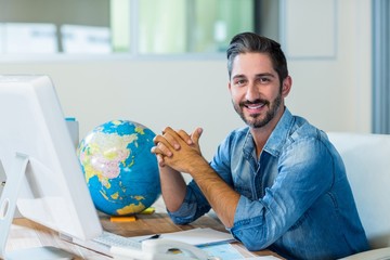 Smiling businessman sitting at his desk
