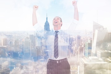 Composite image of handsome businessman cheering with arms up
