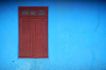 striking blue and red wall and shuttered window