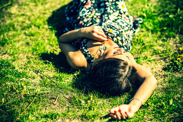Pretty brunette woman relaxing on te grass in the park