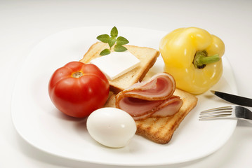 Plate of breakfast with egg, ham and toasts