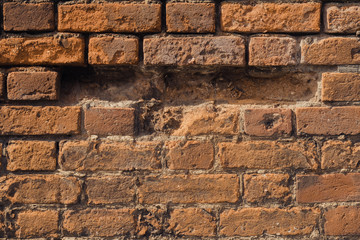 Hole in a weathered brick wall