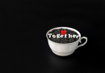 Heart symbol and letters in cup on dark background