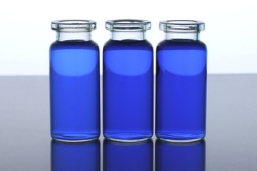three bottles with blue liquid