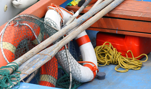 lifebuoys fishing nets and oars in a boat moored