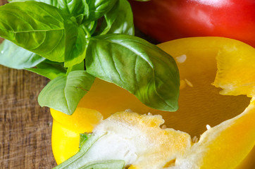 Bulgarian peppers with basil on wooden table