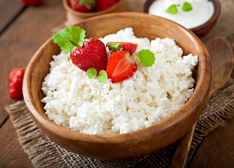 Cottage cheese with strawberries in a wooden bowl