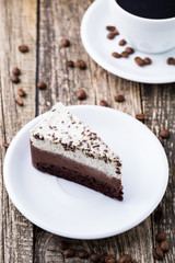 Chocolate dessert with coffee cup and coffee beans on wooden bac
