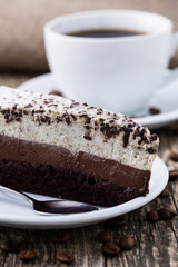 Chocolate dessert with coffee cup and coffee beans on wooden bac