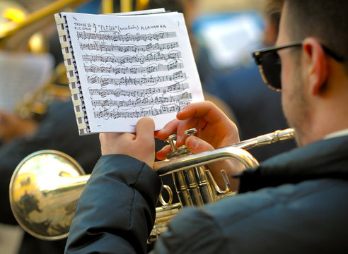 Detail of a musician plays the trumpet reading the score