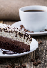 Chocolate dessert with coffee cup and coffee beans on wooden bac