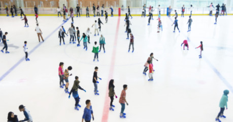 Defocused of indoor ice skating park with skating people.