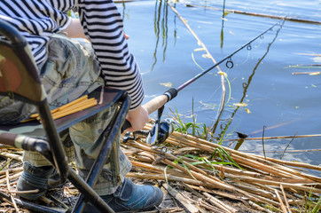 Young boy sitting fishing at a lake