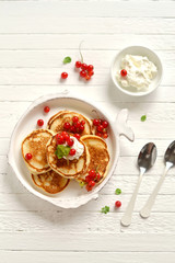 pancakes with cream and red currants in a vintage plate 