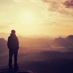 Girl on sharp rock empires above misty valley of the world