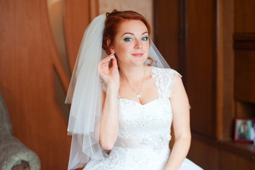 Red-haired bride wears earrings