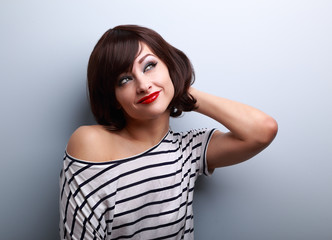 Beautiful smiling thinking young woman looking up