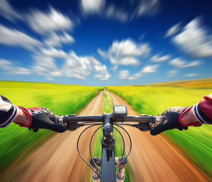 Ride on bicycle on summer field. Sport and active life concept