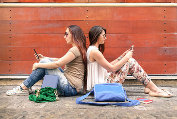 Hipster couple of girlfriends in disinterest moment with phone