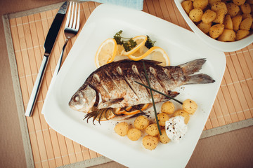 Grilled fish with rosemary potatoes and lemon