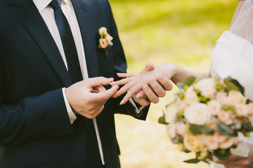 wedding rings and hands of bride and groom