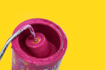 Roller pink brush in can on yellow background - 83675370
