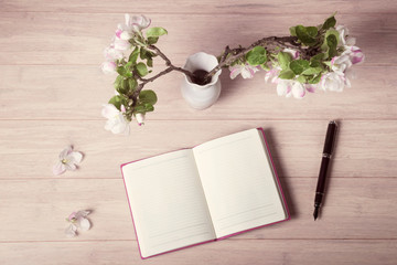 Open notebook with blossoming apple tree branch