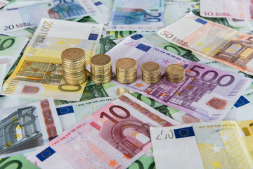 Euro banknotes and coins in example of falling euro prognoses.
