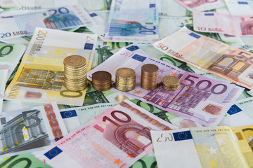 Euro banknotes and coins in example of unpredictable prognoses.