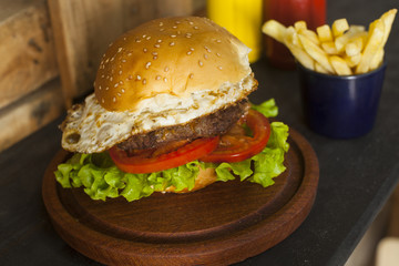 hamburger with fries on wooden table