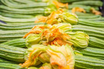 Fresh raw green courgettes with flowers  selective focus