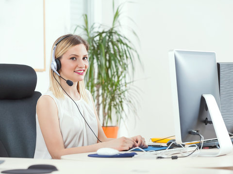 Smiling young woman working in a call center