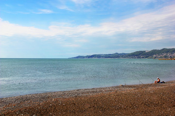 Angler at the beach with three rods