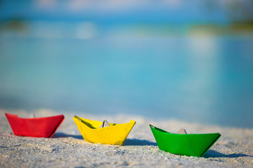 Colorful paper boats on tropical white beach outdoors