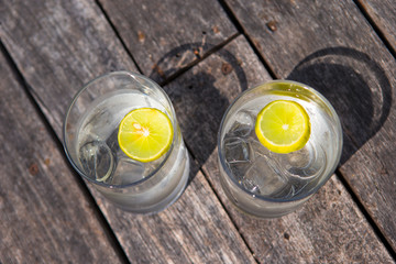 Glasses of waters with lemon on wooden 