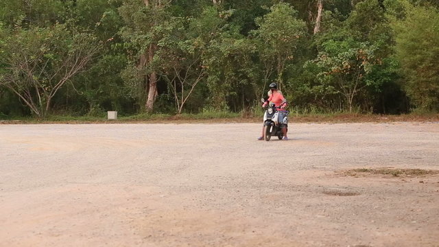 girl drives scooter stops and instructor corrects mistakes	
